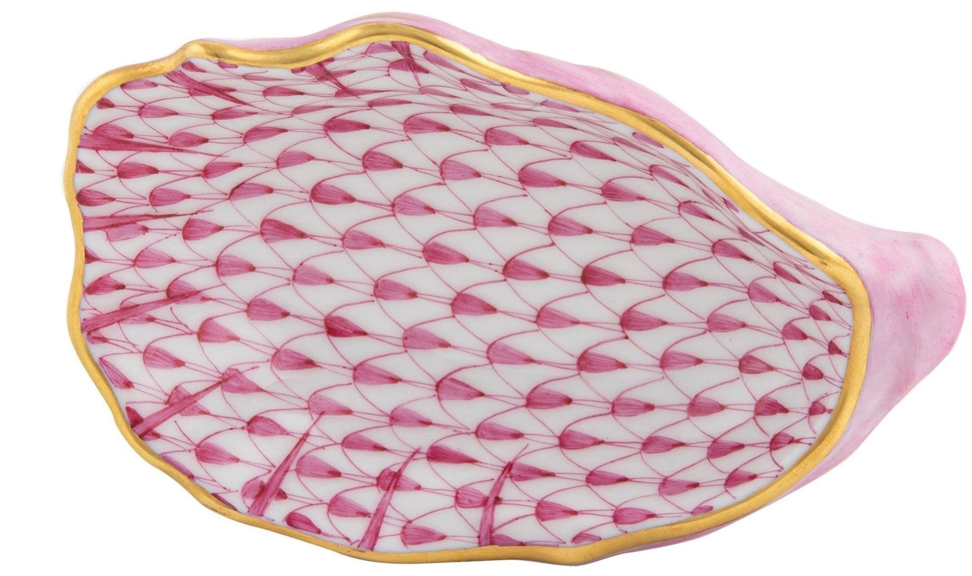 The Herend Oyster Shell is a porcelain dish shaped like a seashell, adorned with the brand’s signature pink fishnet pattern and finished with a gold rim—a hand-painted work of art.