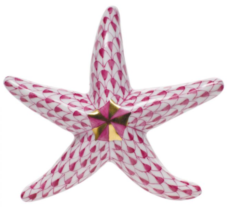 The Herend Miniature Starfish is a hand-painted porcelain figurine featuring a pink and white scale pattern and elegant gold accents at the center.