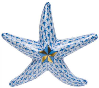 The Herend Miniature Starfish is a blue and white hand-painted porcelain figurine featuring a gold and black star design at its center.