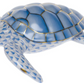 The Herend Loggerhead Turtle is a porcelain figurine featuring hand-painted blue and white scale patterns with gold accents, crafted in the renowned Herend porcelain tradition.