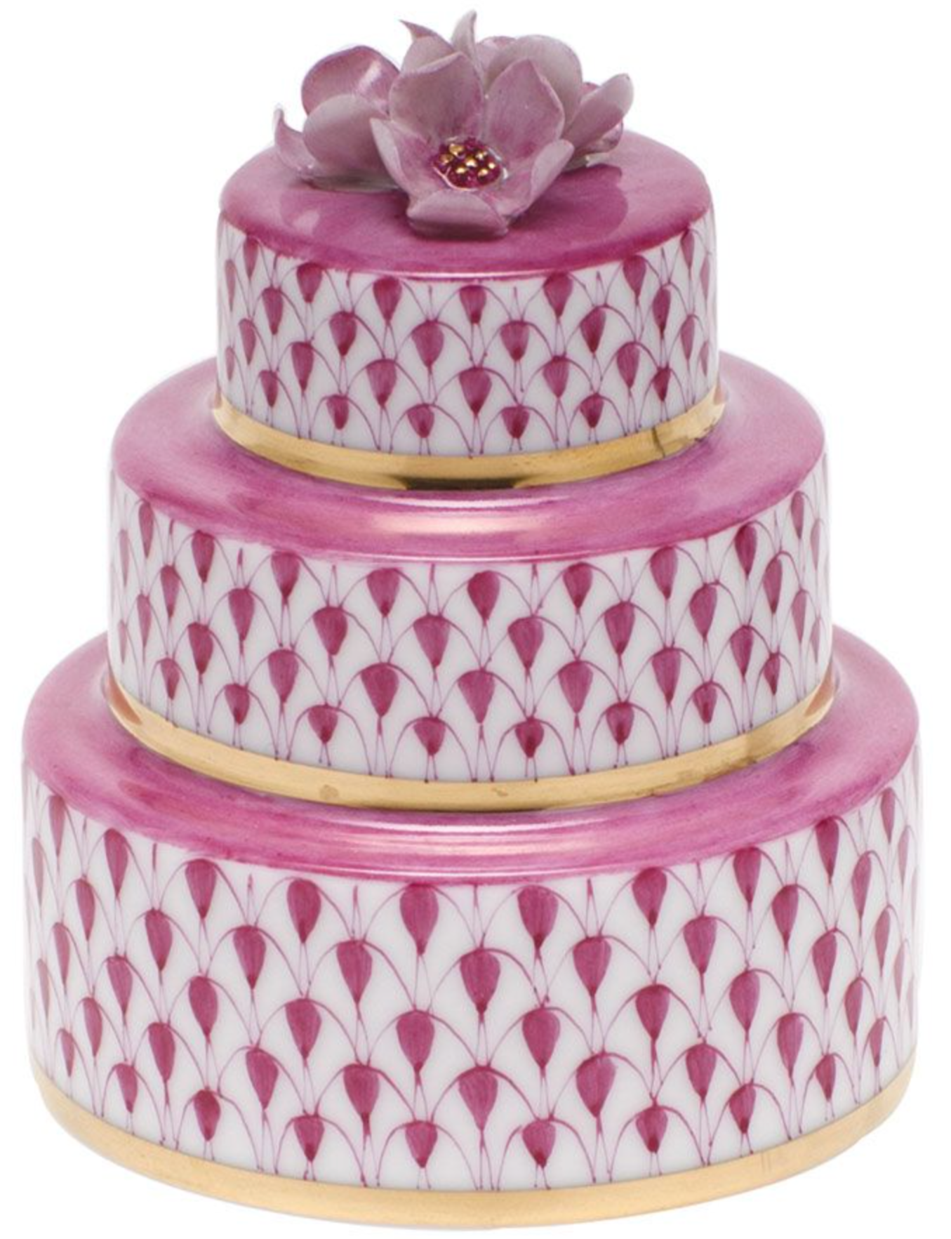 The Herend Wedding Cake is a three-tiered round porcelain box, hand-painted in pink with gold leaf accents and topped with a delicate pink flower ornament.
