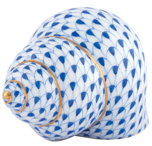 The Periwinkle Shell by Herend features a blue fish scale pattern with gold accents on white porcelain, highlighting Herend's exquisite hand-painted artistry.