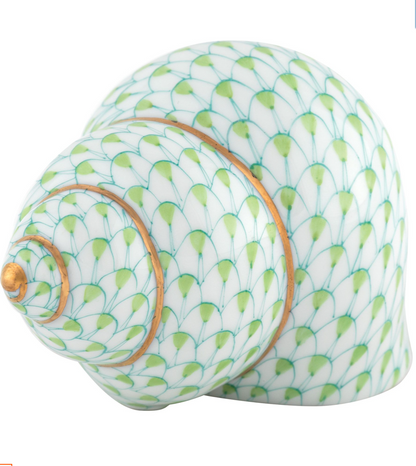 The Herend Periwinkle Shell features a green and white scale pattern with gold accents, highlighting the brand’s renowned hand-painted porcelain craftsmanship.