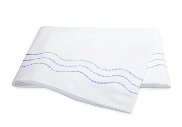 This Matouk Serena Bedding Collection in Azure features a 350 thread count and is made of long-staple cotton. The white sheet is adorned with blue waves for a stylish touch.