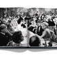 Black and white photo of a formal gathering in an open book. People are seated at round tables, engaging in conversation and dining, with an ornate backdrop reminiscent of Gstaad Glam by Assouline.