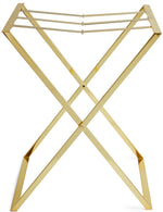 The Aerin Butler Tray Stand is a gold metal luggage rack with an X-shaped frame and three top support straps, perfect for entertaining at home or as a stylish brass stand for guests’ bags.
