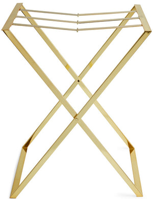 The Aerin Butler Tray Stand is a gold metal luggage rack with an X-shaped frame and three top support straps, perfect for entertaining at home or as a stylish brass stand for guests’ bags.