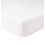 Close-up view of the Yves Delorme Triomphe Fitted Sheet in white cotton sateen, 300 thread count, snugly fitted over a mattress corner.