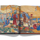 An open book titled "Uzbekistan: Avant-Garde Orientalists" by Assouline reveals a colorful painting of a bustling market scene, teeming with vibrant vendors, fruits, and tents.