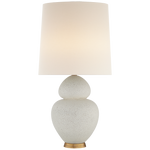 Visual Comfort's Michelena Chalk White Gourd Lamp with a gold accent, topped with a plain linen shade, on a striped table.
