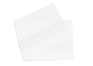 The HIVE Exclusive Matouk Rovella Bedding Collection in white by Matouk features a folded tablecloth with an embroidered lattice pattern on one edge and hemstitch detail that enhances the elegance of any setting.