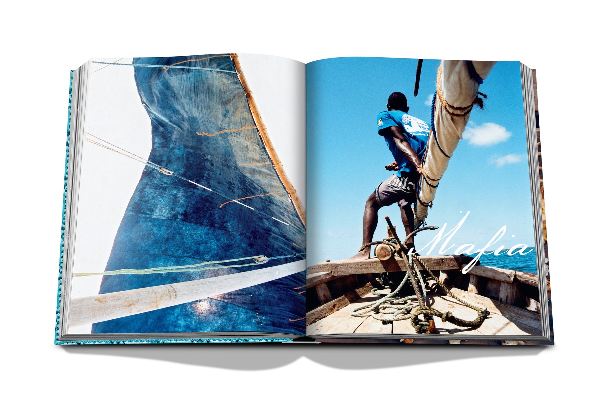 Open book showing a photo of a man on a wooden sailboat with the text "Assouline" on the right page and a close-up of a sail on the left page, cruising near the shores of Zanzibar.