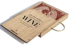 A book-shaped wooden box designed to mimic the appearance of an actual book, titled "The Impossible Collection of Wines: Luxury Edition," with a visible rope handle by Assouline.