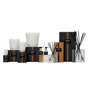 A Nest Moroccan Amber Diffuser, with patchouli notes, is arranged with its packaging against a white background.