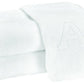 Two Auberge Monogram Bath Towels by Matouk—folded white cotton terry, one with an embroidered "A"—are stacked on a white background, adding elegant charm to any guest bath.