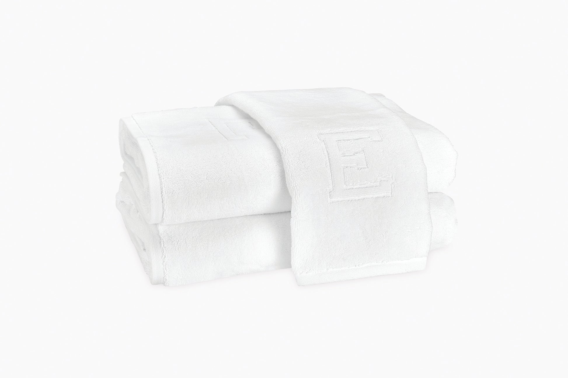 Matouk’s Auberge Monogram Bath Towels, shown neatly folded with an embossed “E,” bring a touch of elegance to any guest bath.