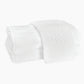 The Auberge Monogram Bath Towels by Matouk feature two white cotton terry towels, one embroidered with a "K" monogram, beautifully displayed against a plain white background—ideal for elevating any guest bath.