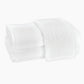 A crisp stack of Matouk Auberge Monogram Bath Towels, with an embossed "M" on top, brings refined elegance to your guest bath.