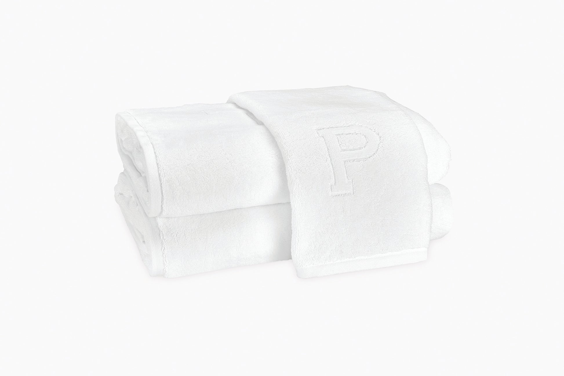 Two folded Auberge Monogram Bath Towels by Matouk, crafted from white cotton terry and embroidered with a "P", are stacked atop each other—perfect for the guest bath—against a plain white background.