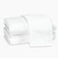Two neatly folded white Auberge Monogram Bath Towels by Matouk, one embossed with a "V," evoke a luxury guest bath experience against a plain white background.