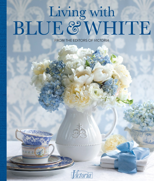 Book cover titled "Common Ground Living with Blue & White" featuring an arrangement of blue and white flowers, a teacup, and a small gift, all set within a blue and white color scheme.