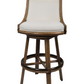 The Rattan Swivel Bar Stool by McGuire Furniture is a 42-inch-tall wooden stool with a cushioned fabric seat and backrest, circular footrest, and splayed legs—compact for any space.