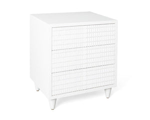 The Lance Bedside Table by Mr Brown is a sleek piece in white, standing 26.5" tall, with a smooth gesso finish on its textured front and complemented by tapered legs.