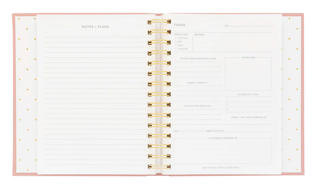 The Mindful Journal by Sugar Paper is an open spiral-bound planner with lined pages for notes on the left and guided sections for daily planning, priorities, intentions, and gratitude on the right.
