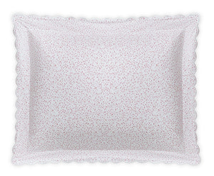 The Matouk Celine Bedding Collection in Pink features a rectangular white pillow with scalloped edges and small red dots, made from OEKO-TEX certified Egyptian cotton percale for premium softness and quality.