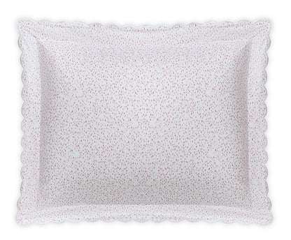 The Matouk Celine Bedding Collection in Pink features a rectangular white pillow with scalloped edges and small red dots, made from OEKO-TEX certified Egyptian cotton percale for premium softness and quality.