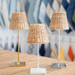 Three Maison Maison x Zafferano Empire Water Hyacinth Shade cordless lamps on a wooden table.