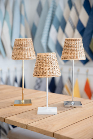 Three Maison Maison x Zafferano Empire Water Hyacinth Shade cordless lamps on a wooden table.