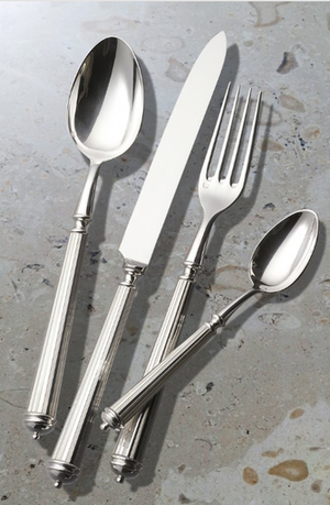 The Alain Saint Joanis Lignes 5 Piece Silver Plated Flatware Set, showcasing quality craftsmanship, is displayed on a light gray stone-textured surface.