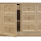 The Kindel Dorothy Door Chest is a beige wooden dresser with ornate drawer fronts and brass ring pull hardware in the Dorothy Draper style, featuring an open door revealing cerused white shelves and an inner drawer.