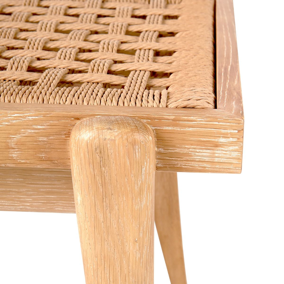 Close-up of a wooden table corner with woven rope detailing reminiscent of African art on the surface and tapered legs, featuring intricate textures found in Villa & House's Dylan Stool.