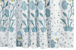 Introducing the Matouk Schumacher Blue Khilana Shower Curtain, a floral-inspired masterpiece crafted from luxurious cotton percale. This exquisite piece features curtains adorned with a botanical pattern of blue and yellow flowers with vibrant green leaves.