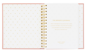 Open "The Mindful Journal, Pink" by Sugar Paper. This daily journal features gold spiral binding and an introduction on the right-hand page, designed to boost productivity and happiness.