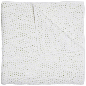 The Stitched Moss Coverlet by John Robshaw is a folded white cotton voile quilt, detailed with short, horizontal green stitches—a striking hand-stitched piece.