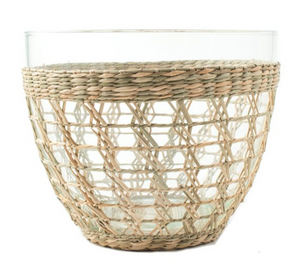 The Be Home Seagrass Cage Serving Bowl combines a glass bowl with an open weave of natural wicker, creating a decorative, interlaced pattern ideal for indoor and outdoor dining.