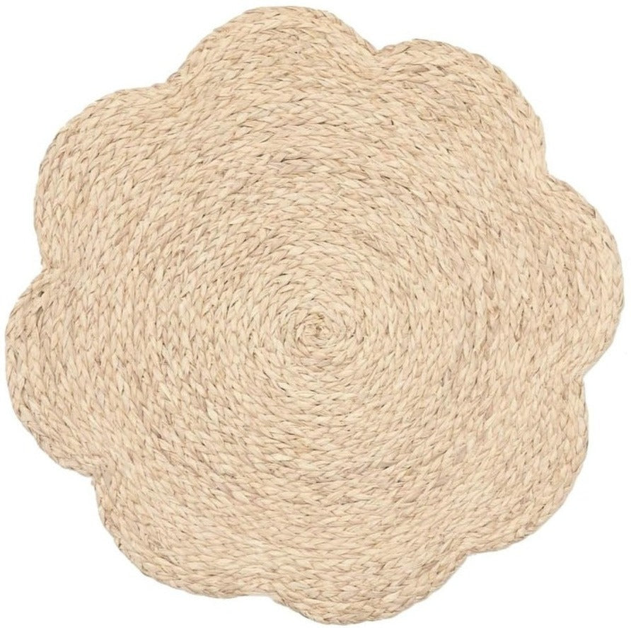 The Blue Pheasant Bleached Flower Placemat features a scalloped floral design, crafted from natural woven bleached raffia, and is shown on a white background.