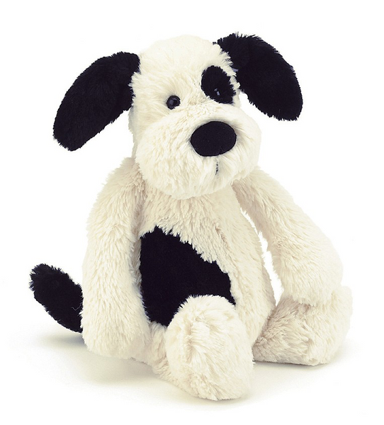  Jellycat black and white stuffed dog sitting on a white background.