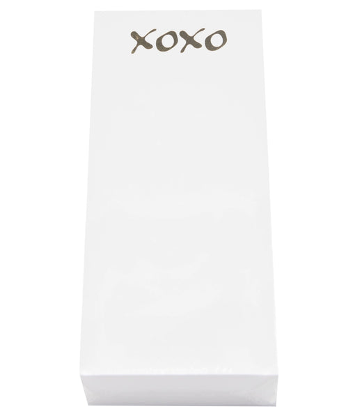 The "Black Ink Skinny Notepad, XOXO" features a rectangular white surface with the word "XOXO" in black, complemented by sophisticated gold foil accents.