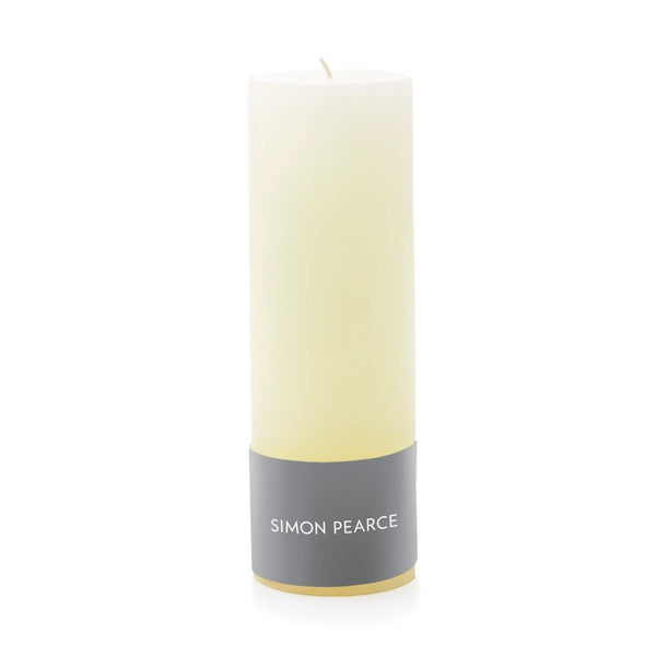 Simon Pearce Ivory Pillar Candle, 2" x 6" with a gray "Simon Pearce" label at the base, against a white background. This unscented candle enhances any decor with its subtle elegance.