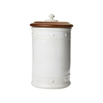 The Juliska Berry & Thread Whitewash 11.5" Canister features raised dot and basket weave details on white ceramic stoneware and a round wooden lid with a knob, displayed against a plain white background.