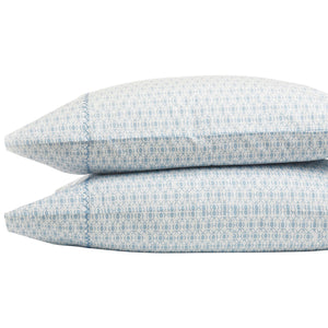 Two stacked pillows from the John Robshaw Kama Bedding Collection feature a light blue geometric design on white organic percale cotton, offering a cool, crisp, and luxurious feel.