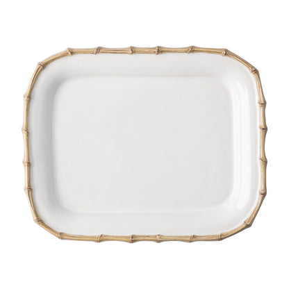 The Juliska Classic Bamboo Small Rectangular Platter is a white ceramic stoneware plate with a raised edge and gold bamboo-style border, adding an exotic touch to any setting. Photographed on a white background.