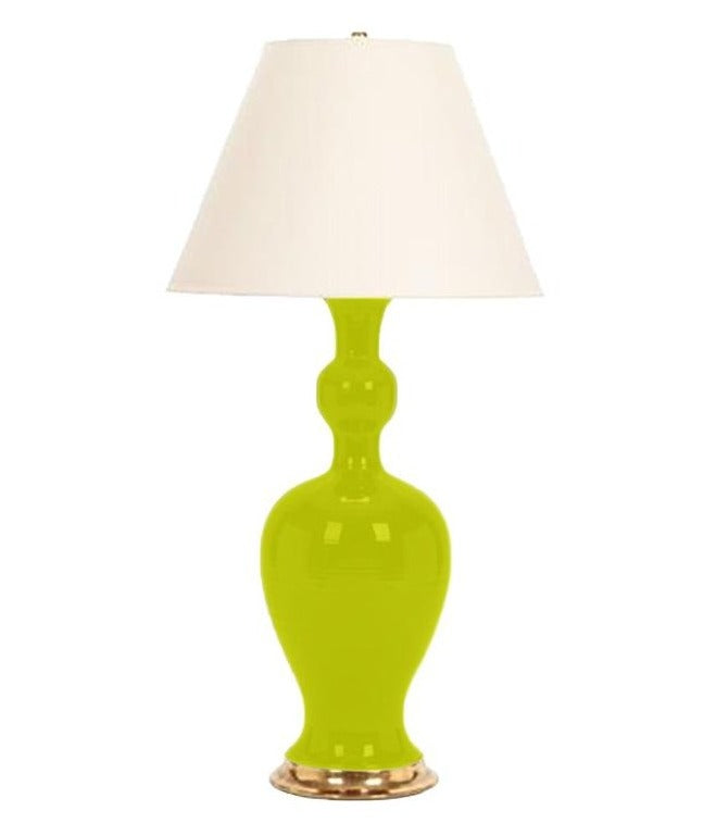 A Marjorie Lamp by Christopher Spitzmiller with a chartreuse table lamp and a white shade and brass double socket cluster.