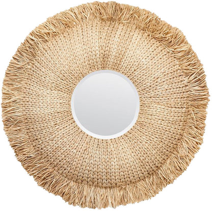 The Casey Round Natural Raffia Mirror by Made Goods features a woven straw frame with a fringed edge, perfect for eclectic décor.