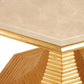 A close-up of the Hourglass Table by Bunny Williams reveals a marble tabletop corner with an antique gold-edged base featuring stepped, geometric ridges.