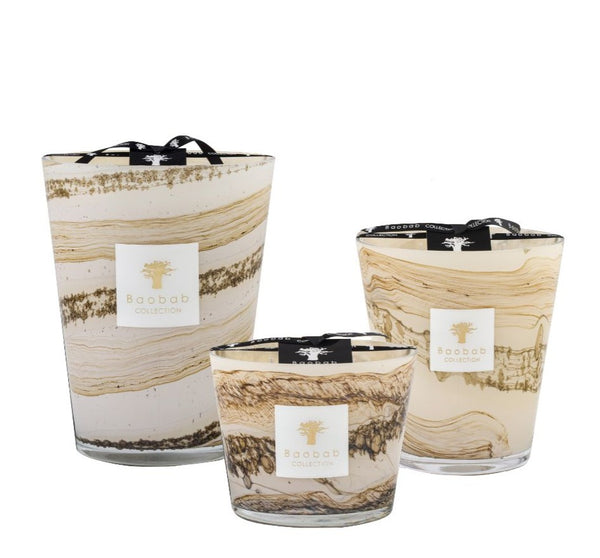 Three Baobab Sand Siloli Collection candles with swirled tan and white designs, displayed in varying sizes against a white background, featuring a subtle cedarwood tonka bean scent.